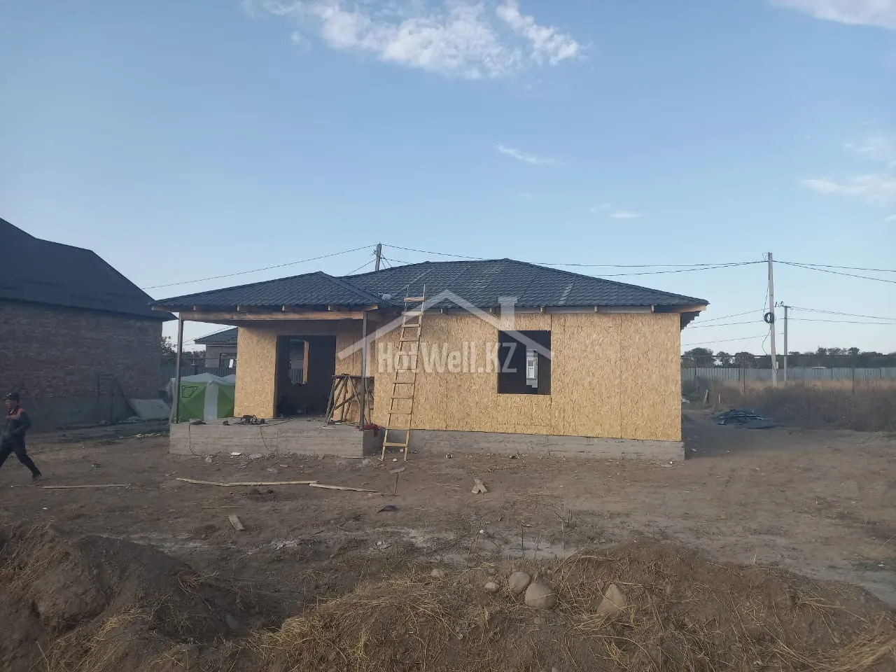 Кровля дома «А-100Б» покрыта тёмной металлочерепицей, продолжаются фасадные работы