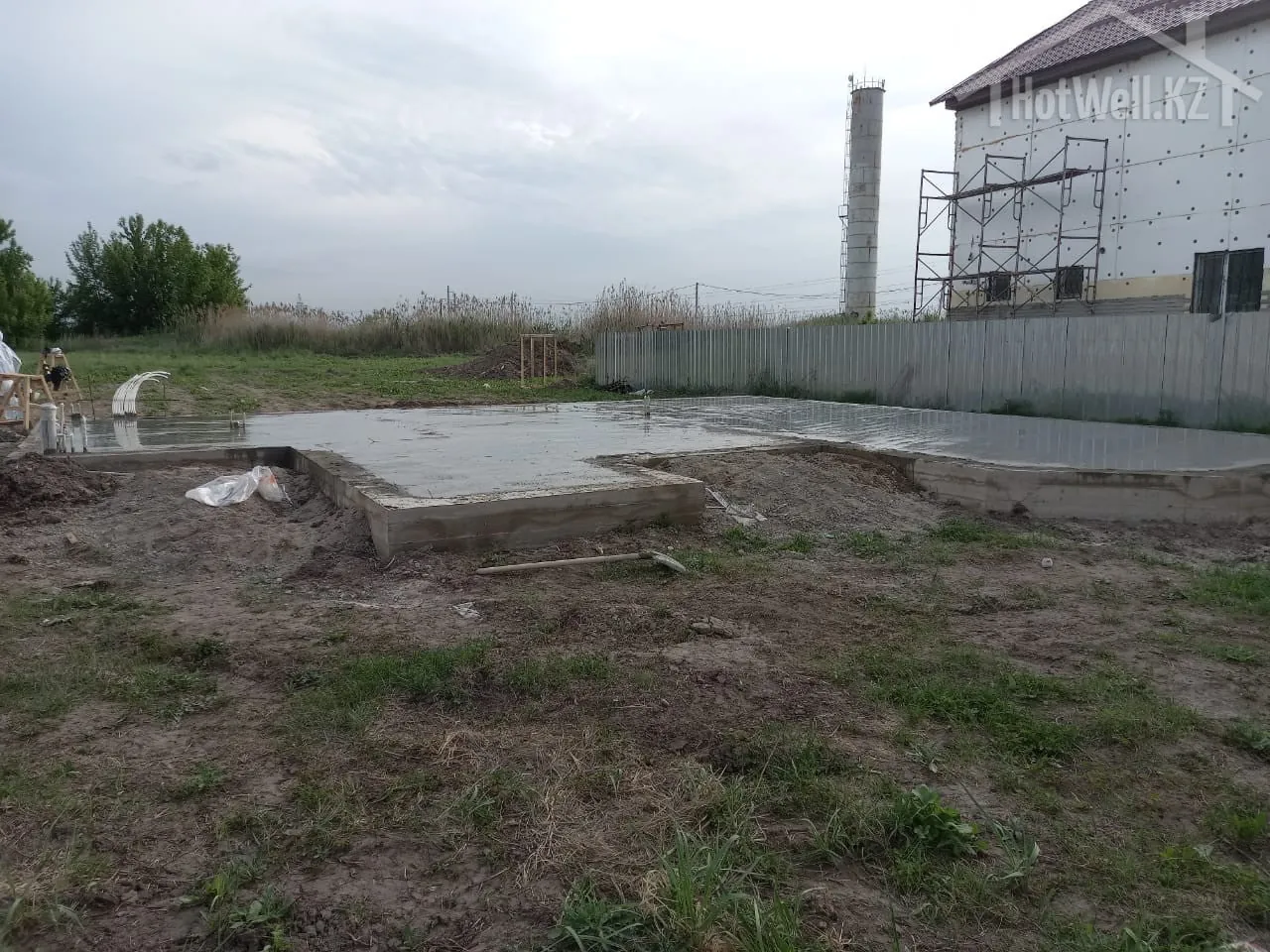 Монолитная плита с тёплым полом под дом «А-217» после заливки, участок у соседней стройки