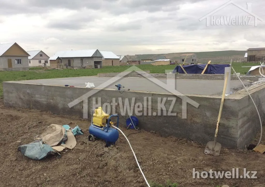 Готовый ленточный фундамент дома «Б-119Б» с гидроизоляцией, рядом компрессор