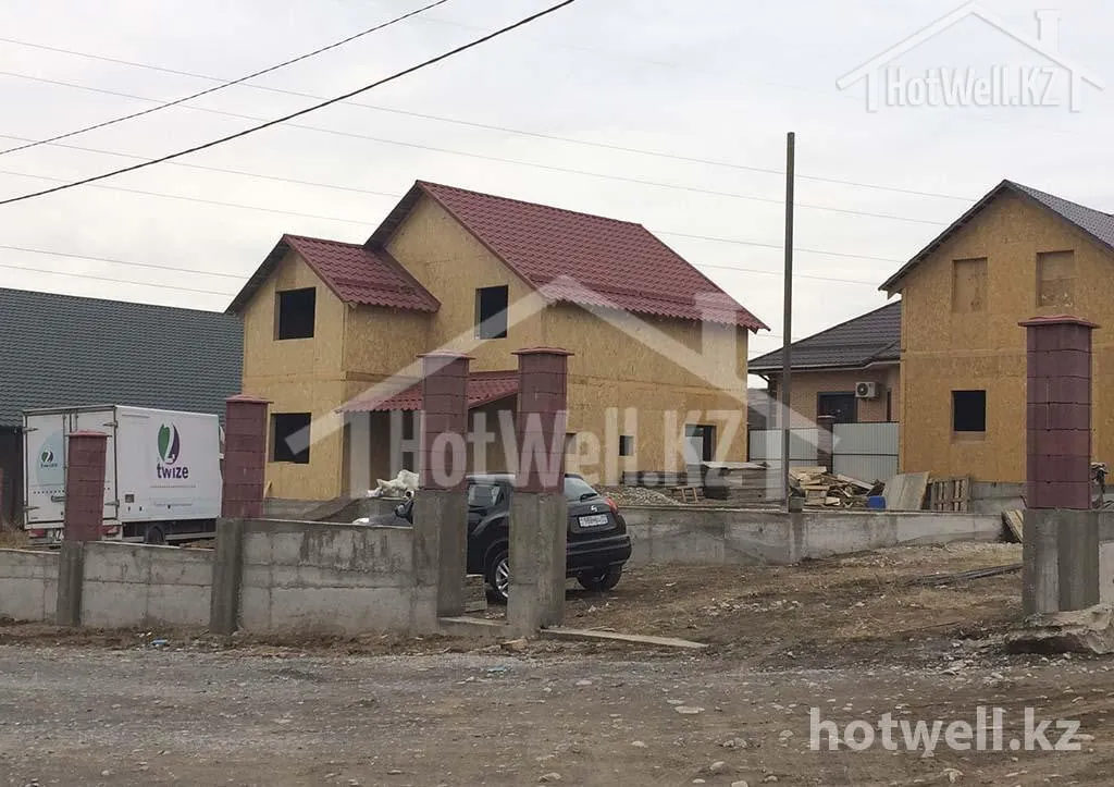 Дом «Б-173» из СИП-панелей под бордовой крышей: вид с улицы через ограждение