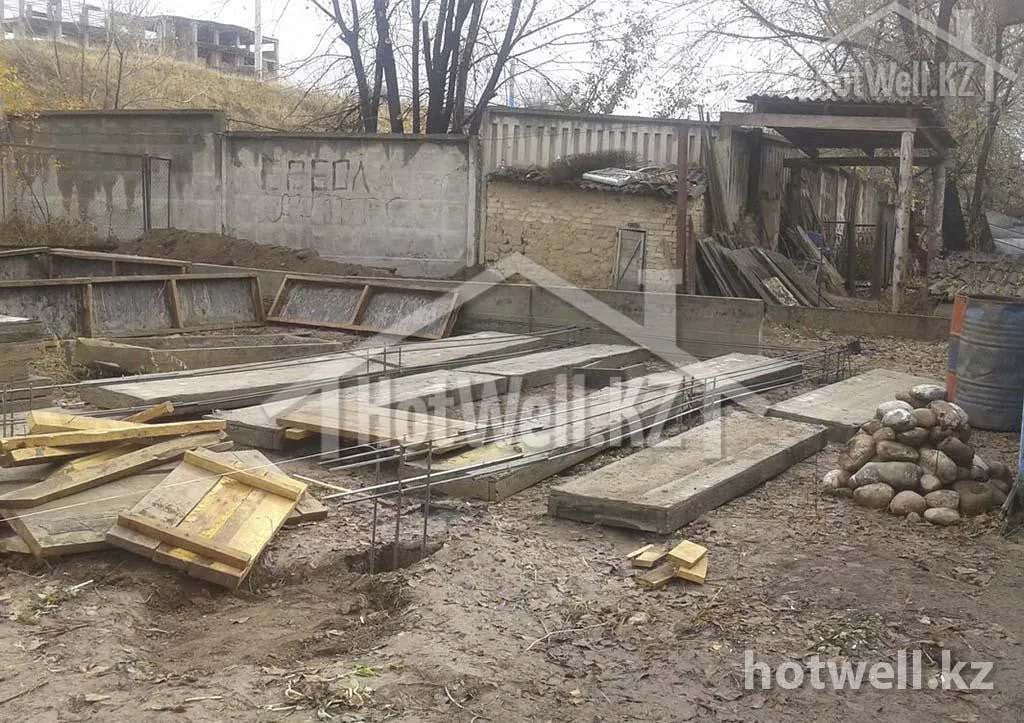 Щиты опалубки и арматурные каркасы разложены под ленточный фундамент дома «Б-205»