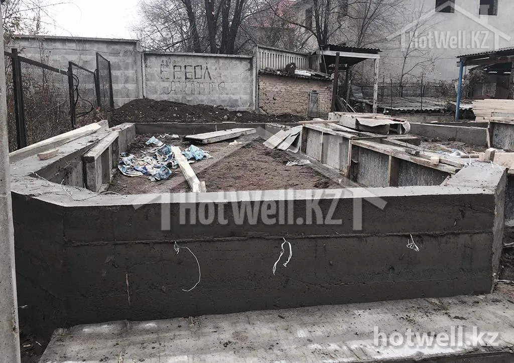 Залитый ленточный фундамент дома «Б-205» после распалубки, внутри — грунтовая засыпка