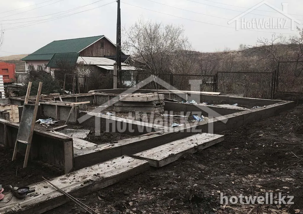 Ленточный фундамент дома «Б-205» с опалубкой на участке, вид со двора