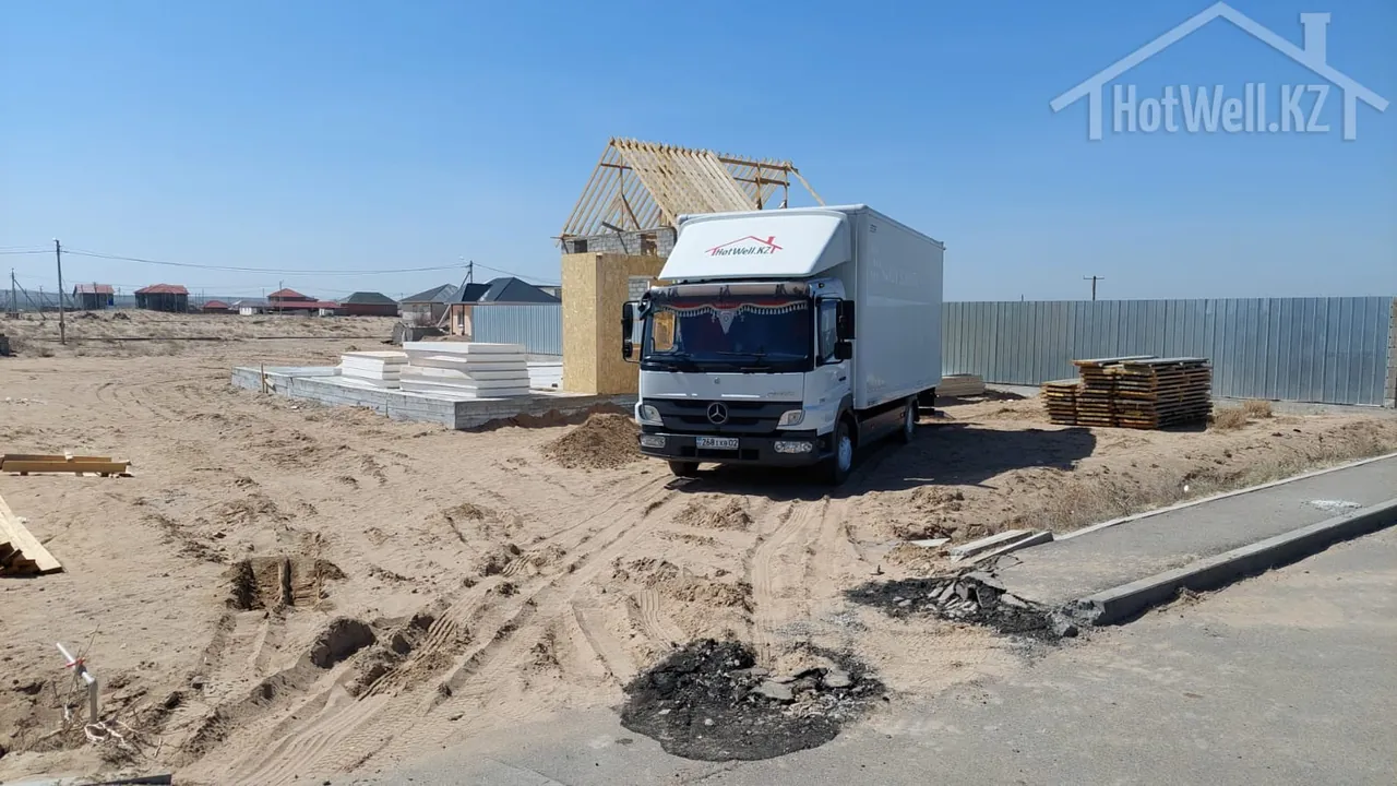 Грузовик компании с домокомплектом СИП-панелей на участке строительства дома «К-184»