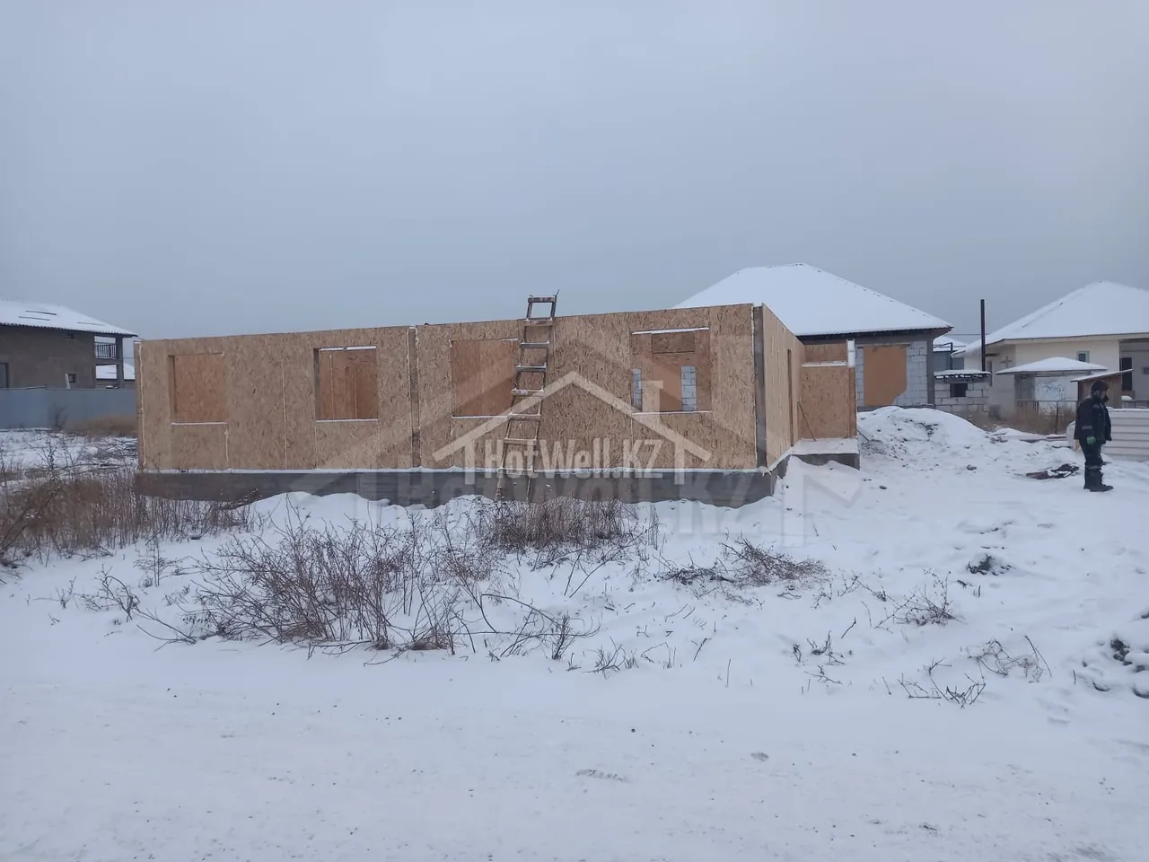 Угловой вид стен первого этажа «К-279», монтажник закрепляет СИП-панели