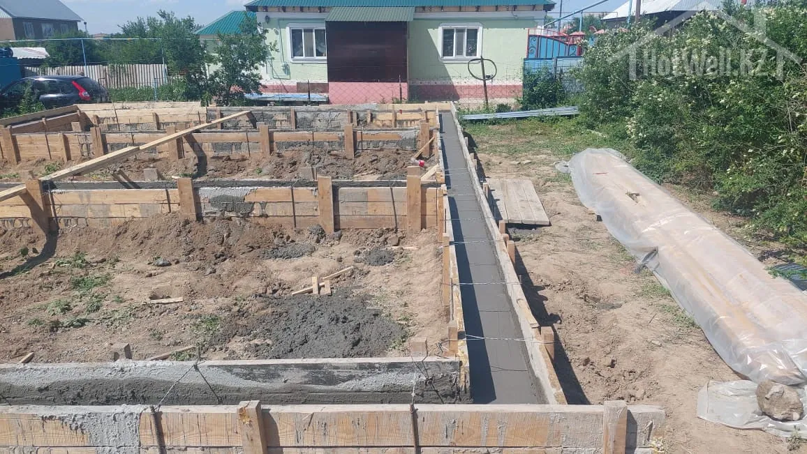 Заливка ленточного фундамента дома «Л-94»: свежий бетон в деревянной опалубке