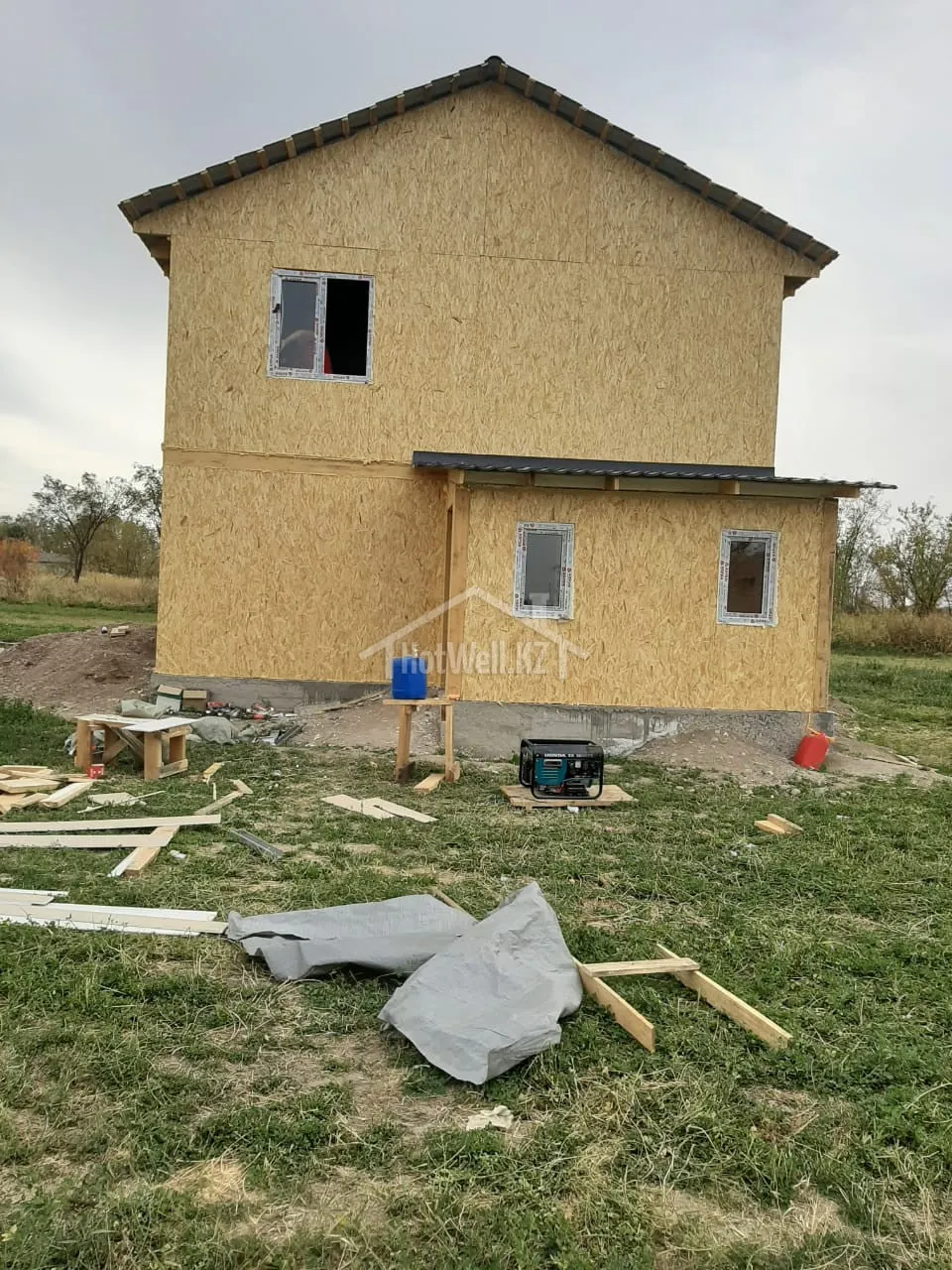 Фасад дома «М-107А» с установленными окнами и навесом над пристройкой