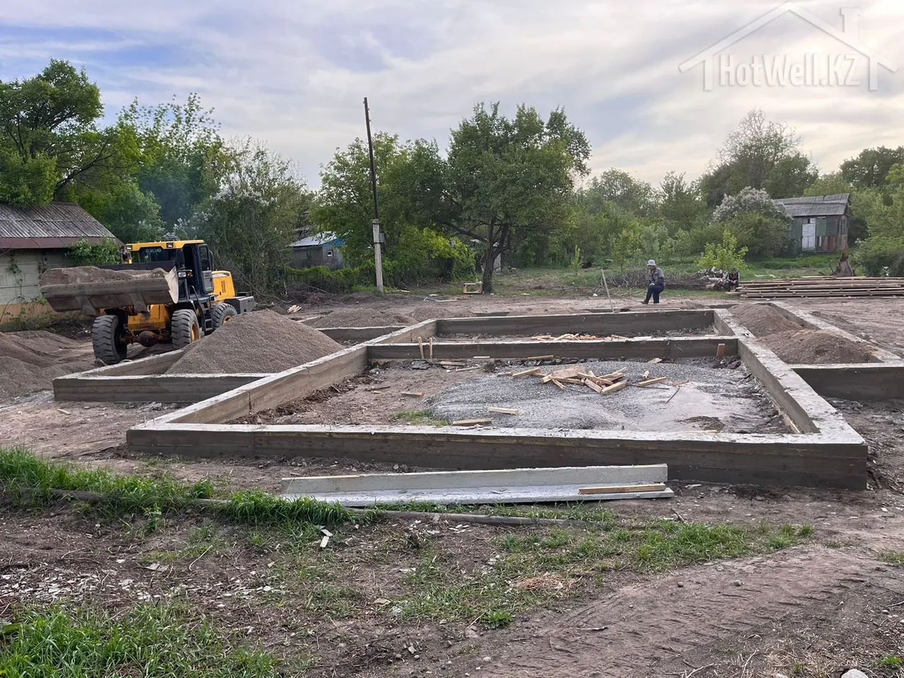 Фронтальный погрузчик засыпает песчаную подушку в фундамент дома «Н-280»