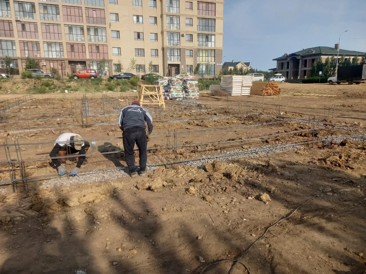 Рабочие вяжут арматуру ленточного фундамента дома «А-317» в Астане