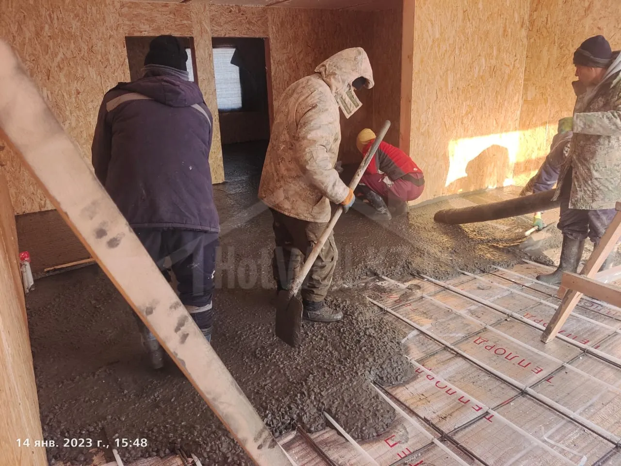 Устройство тёплого пола в доме «К-300»: рабочие заливают бетонную стяжку по трубам и утеплителю