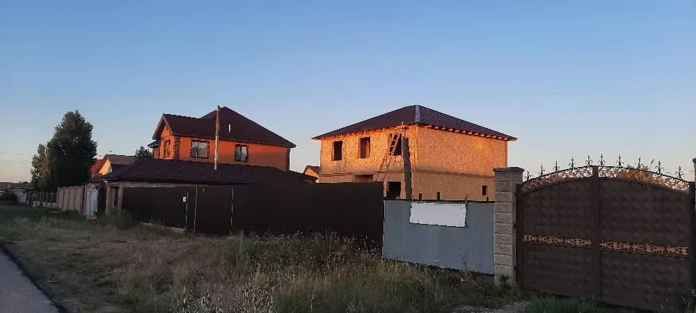 Двухэтажный дом «С-170» из СИП-панелей с готовой крышей, вид из-за забора участка