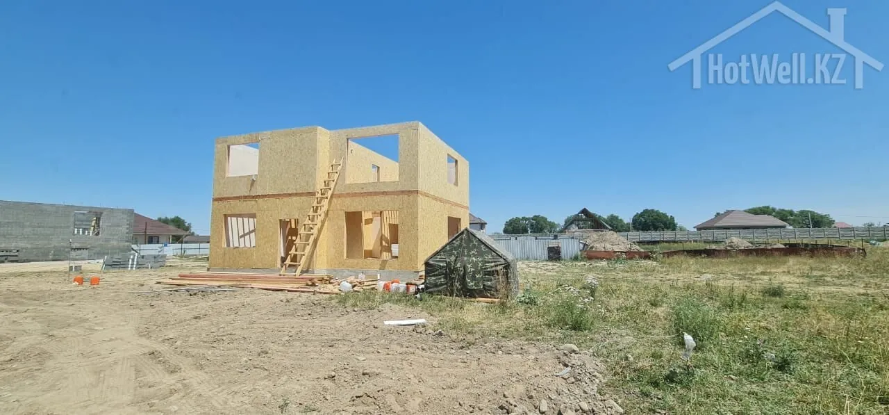 Собранная коробка дома «Р-175» 175 м² на участке, рядом палатка строительной бригады