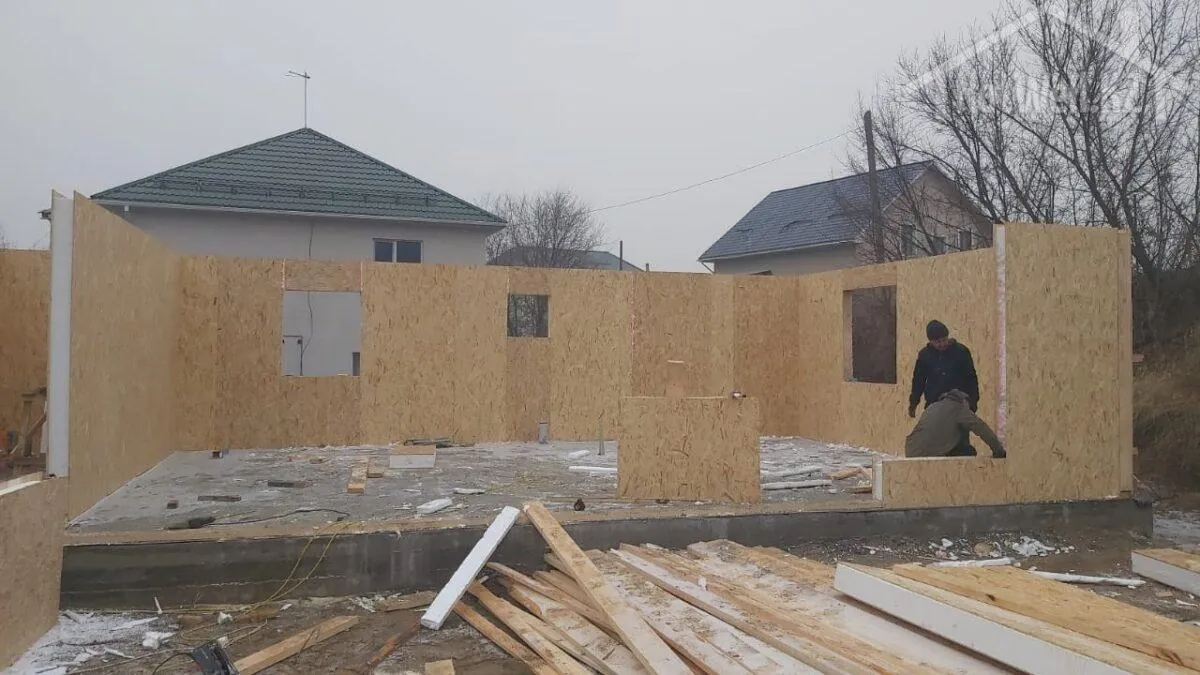 Монтажники собирают наружные стены и перегородки дома из СИП-панелей