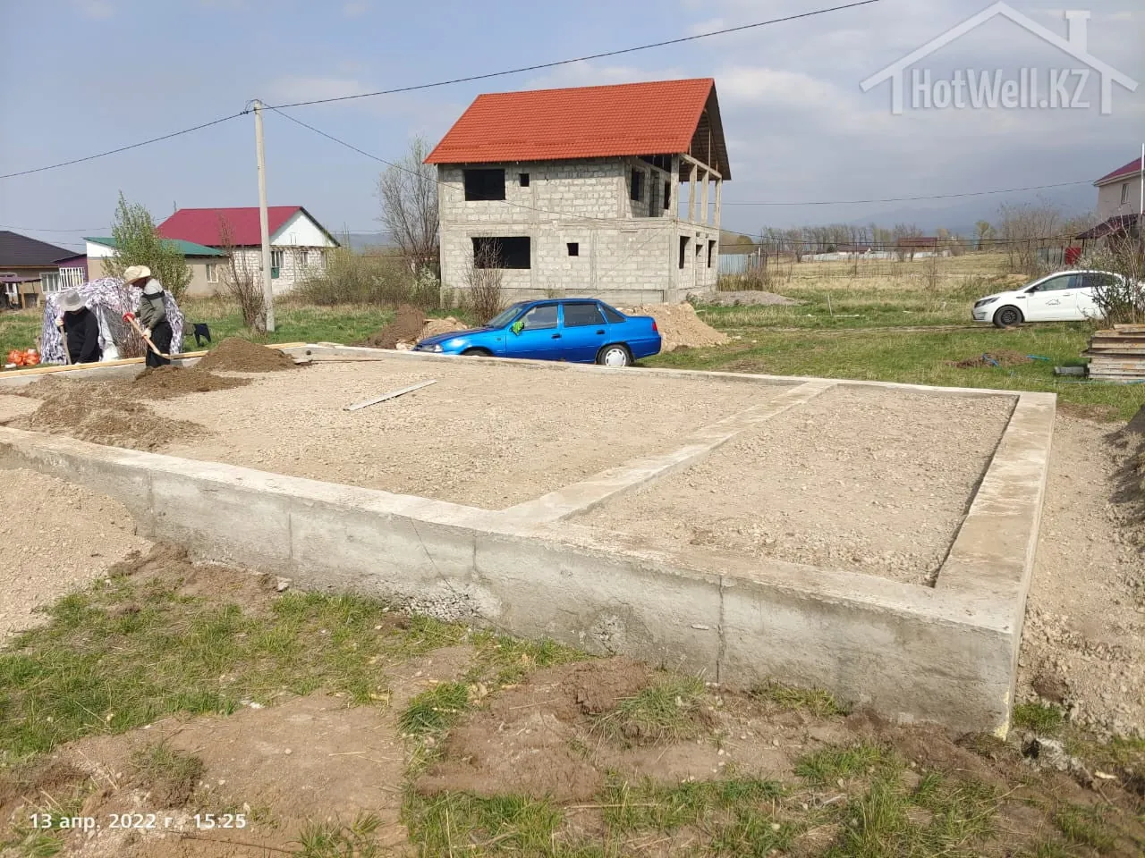 Лента фундамента дома «В-112» с гравийной подушкой, рабочие разравнивают засыпку